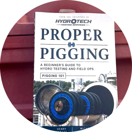 The printed Proper Pigging field guide propped against a red pipeline gate valve at a hydrostatic test site.